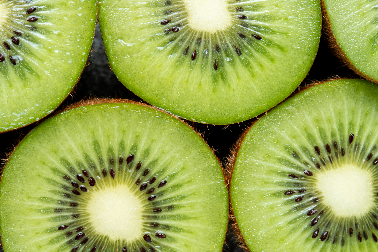 Tranches de kiwi frais de la Ferme Pellausy à villemur-sur-tarn, chair verte juteuse et graines noires