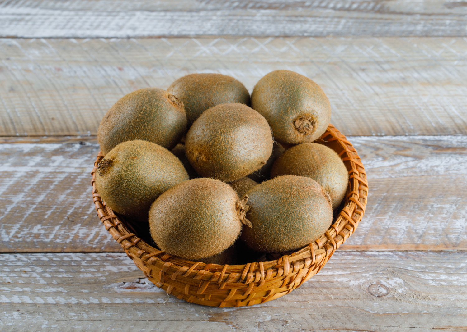 Panier de kiwis frais sur table en bois à la Ferme Pellausy à villemur-sur-tarn